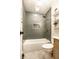 Well-lit bathroom features a tub-shower combo, modern gold fixtures, and stylish shelving at 2835 S Lyons Ave, Indianapolis, IN 46241