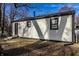 The back of this home features neutral siding, black trim, and a dark front door, presenting a clean and modern look at 2835 S Lyons Ave, Indianapolis, IN 46241