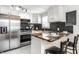 Bright renovated kitchen boasts stainless steel appliances, honeycomb backsplash, and stylish breakfast bar at 2835 S Lyons Ave, Indianapolis, IN 46241