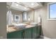 Updated bathroom boasts double sinks with vessel sinks, green cabinets, and granite counters at 3849 Waycross Dr, Columbus, IN 47203