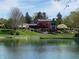 Beautiful waterfront home with landscaped lawn and mature trees reflecting in the lake at 3849 Waycross Dr, Columbus, IN 47203
