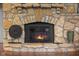 Close-up of the stone fireplace with a fire burning at 3849 Waycross Dr, Columbus, IN 47203