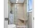 Tiled shower features a glass door, rainfall shower head, and built-in bench at 3849 Waycross Dr, Columbus, IN 47203