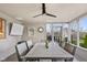 Relaxing screened porch with a ceiling fan, outdoor dining, and a TV at 3849 Waycross Dr, Columbus, IN 47203