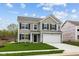 Charming two-story home featuring gray siding, black shutters, a two-car garage, and a well-manicured lawn at 3913 Highcrest Rd, Indianapolis, IN 46239