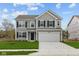 Charming two-story home featuring gray siding, black shutters, a two-car garage, and a well-manicured lawn at 3913 Highcrest Rd, Indianapolis, IN 46239