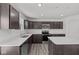 Modern kitchen featuring dark cabinetry, stainless steel appliances, an island, and sleek countertops at 3913 Highcrest Rd, Indianapolis, IN 46239