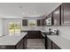 Modern kitchen featuring dark cabinetry, stainless steel appliances, an island, and sleek countertops at 3913 Highcrest Rd, Indianapolis, IN 46239