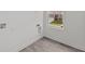 Bright laundry room with gray vinyl flooring, washer/dryer hookups, and a view of the home's exterior at 3913 Highcrest Rd, Indianapolis, IN 46239