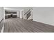 Open-concept living room with modern flooring, fireplace, staircase, and adjacent kitchen space at 3913 Highcrest Rd, Indianapolis, IN 46239