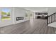 Open-concept living room with modern flooring, fireplace, bright windows, and adjacent kitchen space at 3913 Highcrest Rd, Indianapolis, IN 46239