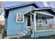 Charming blue house featuring a covered front porch, offering curb appeal and a welcoming entrance at 3932 Caroline Ave, Indianapolis, IN 46205
