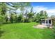 Expansive backyard with lush green lawn, mature trees, and a patio area at 4146 Roselawn Ave, Columbus, IN 47203