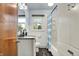 Well-lit bathroom featuring a shower-tub combo, wood-look flooring, and storage at 4146 Roselawn Ave, Columbus, IN 47203