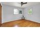 Bright bedroom with hardwood floors, ceiling fan, and two windows offering natural light at 4146 Roselawn Ave, Columbus, IN 47203