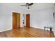Clean bedroom with hardwood floors, a ceiling fan, and natural wood closet doors at 4146 Roselawn Ave, Columbus, IN 47203