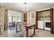 Dining area with wood table, stylish lighting, adjacent to a screened-in porch and laundry closet at 4146 Roselawn Ave, Columbus, IN 47203