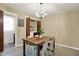 Dining room features modern chandelier, wood table, and convenient closet with in-unit washer and dryer at 4146 Roselawn Ave, Columbus, IN 47203