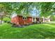 Brick home with green lawn and landscaping including mulch and shrubbery, side view at 4146 Roselawn Ave, Columbus, IN 47203