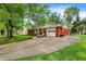 Ranch home with brick and white siding, attached garage, with extended driveway and manicured green grass at 4146 Roselawn Ave, Columbus, IN 47203