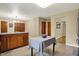 Open-concept kitchen area with center island table, wood cabinets, and seamless flow to other rooms at 4146 Roselawn Ave, Columbus, IN 47203