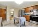 Bright kitchen with wood cabinets, stainless appliances, island table, and seamless transition to other living spaces at 4146 Roselawn Ave, Columbus, IN 47203