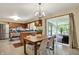 Inviting eat-in kitchen boasts modern lighting, wood table, and glass doors that lead to screened-in porch at 4146 Roselawn Ave, Columbus, IN 47203