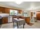 Charming kitchen features wood cabinetry, stainless steel appliances, island table, and adjacent dining area at 4146 Roselawn Ave, Columbus, IN 47203