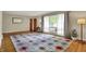 Bright living room with hardwood floors, large window, and a decorative rug at 4146 Roselawn Ave, Columbus, IN 47203