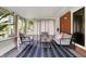 Relaxing sunroom with neutral furniture, brick accent wall, and large area rug at 4146 Roselawn Ave, Columbus, IN 47203