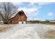 Barn view with two garage door bays, gravel lot, and speed limit sign at 435 N Chestnut St, Monrovia, IN 46157