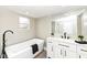 Elegant bathroom featuring soaking tub, modern fixtures, vanity with sink, and wood-look flooring at 435 N Chestnut St, Monrovia, IN 46157