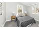 Cozy bedroom with two windows, stylish lamps, and a comfortable bed with decorative pillows at 435 N Chestnut St, Monrovia, IN 46157