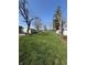 Large backyard featuring a well-maintained lawn, detached garage, mature trees, and partial fence at 4904 Betholm Dr, Indianapolis, IN 46239