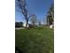 Spacious backyard with a lush lawn, mature trees, a storage shed, and a basketball hoop at 4904 Betholm Dr, Indianapolis, IN 46239