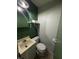 Cozy bathroom featuring a white sink and a white toilet with stylish green wallpaper at 4904 Betholm Dr, Indianapolis, IN 46239