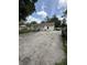 Back exterior view of home, showcasing a large driveway, grill, and yard at 4904 Betholm Dr, Indianapolis, IN 46239
