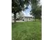 View of the detached garage in a spacious yard, complemented by mature trees and a clear sky backdrop at 4904 Betholm Dr, Indianapolis, IN 46239