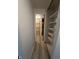 Hallway featuring an adjacent bathroom and storage shelves at 4904 Betholm Dr, Indianapolis, IN 46239