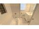 Clean, bright bathroom featuring a tub with tiled walls, a modern vanity, and a window at 4929 Kingsley Dr, Indianapolis, IN 46205