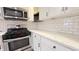 Well-lit kitchen featuring white cabinets, subway tile backsplash, stainless steel appliances, and granite countertops at 4929 Kingsley Dr, Indianapolis, IN 46205