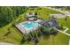 Stunning aerial view of the pool with chairs and a playground surrounded by green grass and trees at 5120 Melbourne Pl, Zionsville, IN 46077