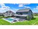 Stunning backyard featuring a modern pool, stylish lounge furniture, covered patio, lush landscaping, and a well-maintained lawn at 5120 Melbourne Pl, Zionsville, IN 46077