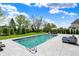 Serene backyard featuring a sparkling pool with water features, comfortable seating, and meticulously maintained landscaping at 5120 Melbourne Pl, Zionsville, IN 46077