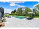 Gorgeous backyard pool with lounge furniture, manicured lawn, and mature trees offering a private and serene outdoor space at 5120 Melbourne Pl, Zionsville, IN 46077