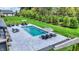 Beautiful backyard with a rectangular pool, chic lounge seating, manicured lawn, mature trees, and elegant landscaping at 5120 Melbourne Pl, Zionsville, IN 46077