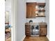 Charming bar area featuring custom cabinets, a wine fridge, and elegant marble countertops at 5120 Melbourne Pl, Zionsville, IN 46077