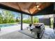 Inviting covered patio with wood ceiling, fan, and comfortable seating overlooking the pool and backyard at 5120 Melbourne Pl, Zionsville, IN 46077