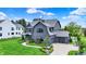 Beautiful two-story home with a driveway leading to an attached garage, complemented by manicured lawn and mature trees at 5120 Melbourne Pl, Zionsville, IN 46077