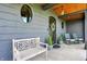Inviting front porch with bench seating, round windows, stone base and rocking chairs at 5120 Melbourne Pl, Zionsville, IN 46077